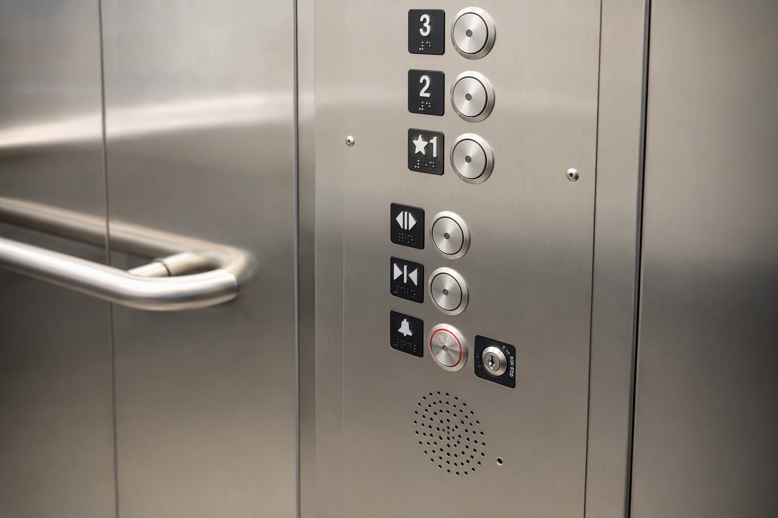 Close-up of ADA-compliant elevator control panel with Braille buttons and two-way intercom inside a senior living facility, meeting federal senior living elevator requirements.