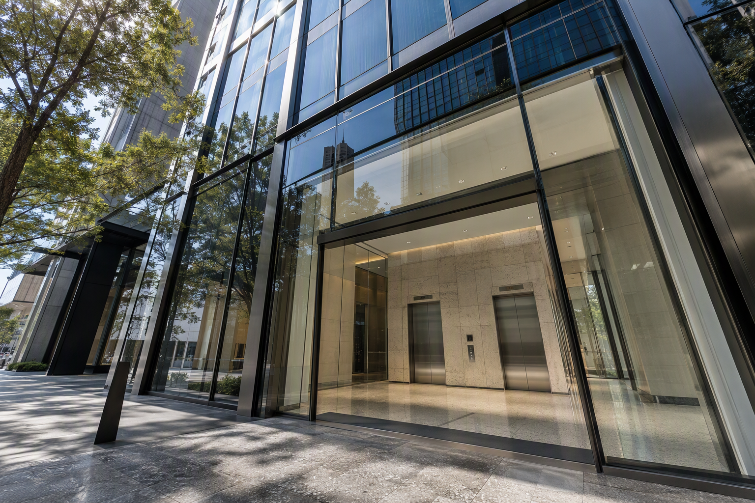 Modern Houston Texas commercial high-rise building exterior with elevator lobby visible through glass facade, served by a certified elevator company in Texas.
